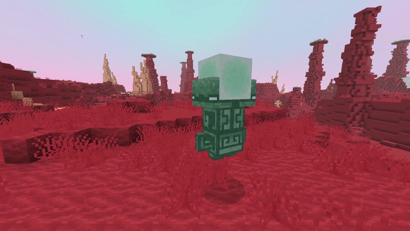 Minecraft screenshot of a green stone golem with a glass dome for a head, standing on red grass between tall red rock pillars