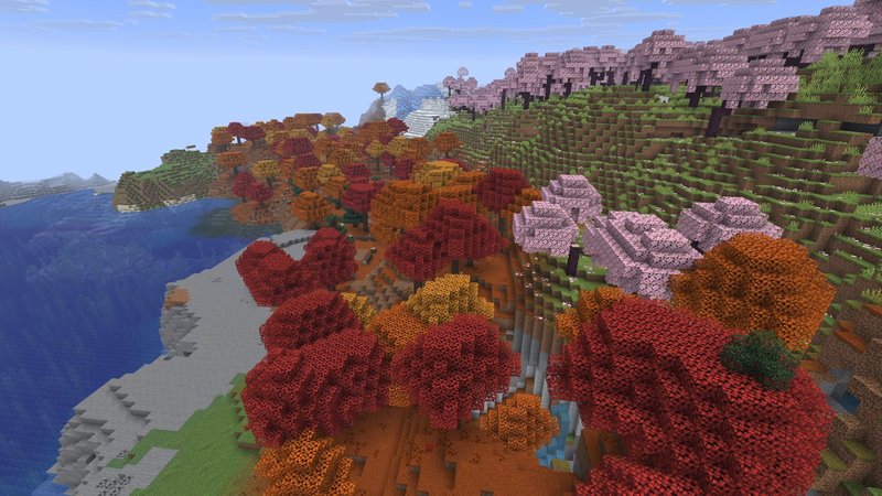 Minecraft screenshot from above: a Dappled Forest with red, orange and yellow poplar trees between a cherry grove and a lake