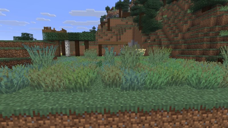 Split Minecraft screenshot of a meadow: left half vanilla grass, right half with OS' Colorful Grasses, bushy tufts in green, blue-green and yellow shades