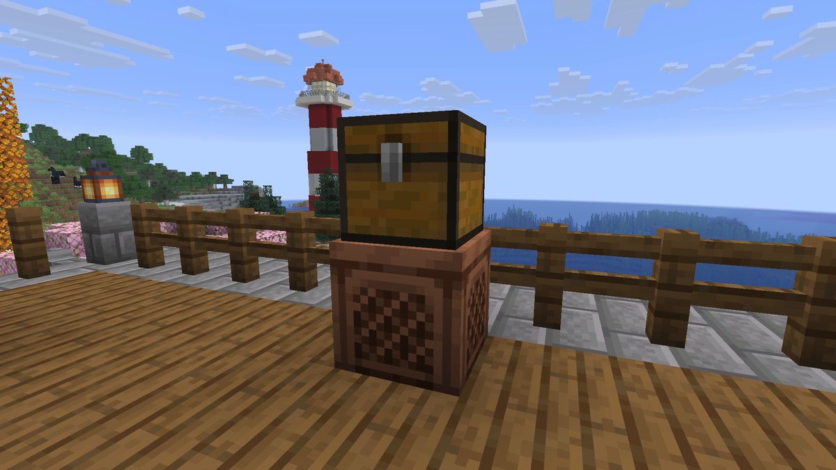 A chest standing on a jukebox on a wooden terrace above a bay